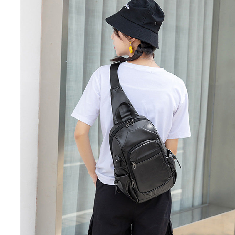 Kleine schwarze Sling-Umhängetasche für Damen und Herren, Tagesrucksack mit USB-Ladegerät
